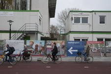 827601 Afbeelding van enkele fietsers op het fietspad langs de Van Sijpesteijnkade te Utrecht, met de bouwschutting met ...